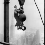 29 Sep 1930, Manhattan, New York City, New York State, USA --- A steel worker hangs stories above the streets of Manhattan while holding onto the end of a crane hook at the construction site of the Empire State Building. The Chrysler Building is viewable in the distance. --- Image by © Bettmann/CORBIS